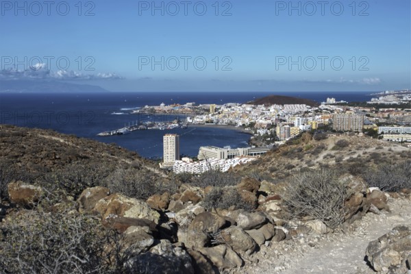 Hill view of the tourist town of Los Cristianos and the blue sea on a sunny day, Los Cristianos