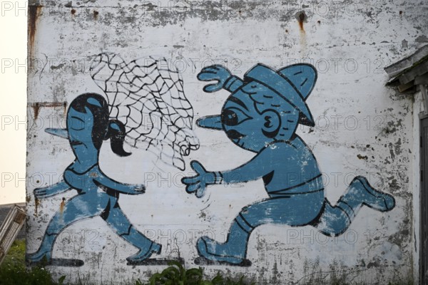 Mural in which a fisherman catches a woman with a net. By Husk Mit Navn. Vardö street art