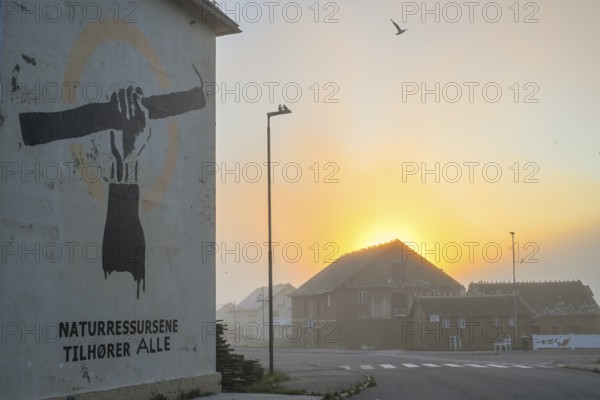Wall painting with stretched arm and gaff. The inscription says Natural resources belong to