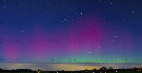 Glowing polar lights in shades of purple and green under a clear starry sky, EXPO Observatory