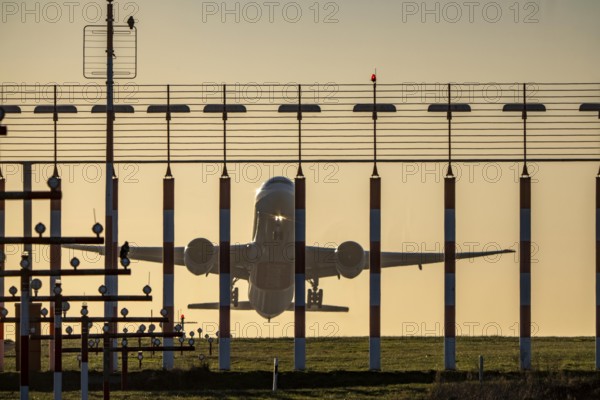 Runway lighting, approach aids, at Düsseldorf International Airport, sunset, aircraft taking off,
