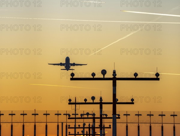Runway lighting, approach aids, at Düsseldorf International Airport, sunset, aircraft taking off,