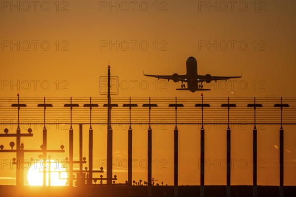 Runway lighting, approach aids, at Düsseldorf International airport, sunset, aviator taking off, in