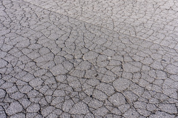 Asphalt surface, floor, with many small cracks, roadway, parking lot