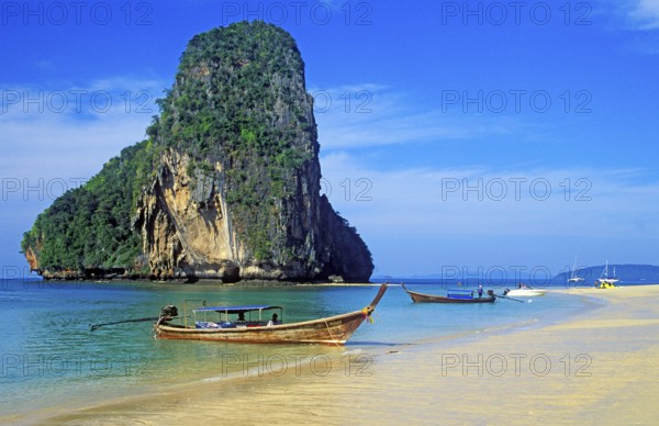 Rocks in the sea and longtail boats on Pranang Cave beach, two years in front of the tsunami,