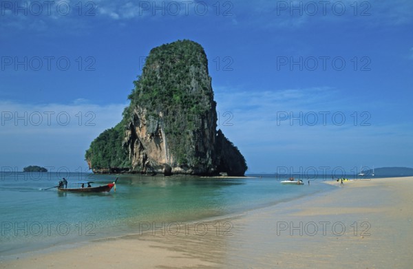 Rocks in the sea and longtail boat on Pranang Cave beach, two years in front of the tsunami, Krabi,