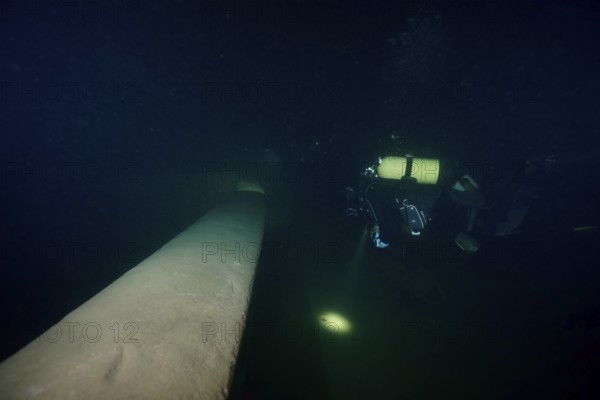 Diver examines a lediwreck, wreck of a lediship, ledi ship, cargo ship for mass freight, bulk