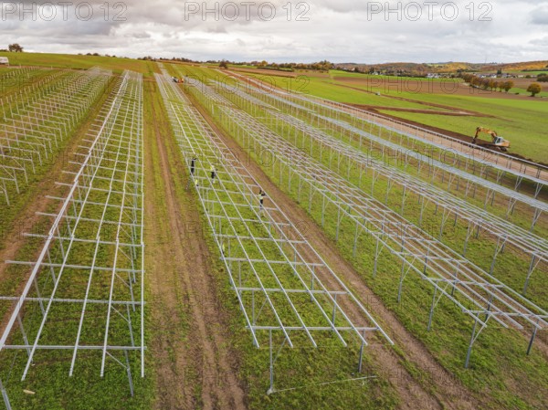 Technical structures of a solar plant under construction on wide fields, energy revolution,