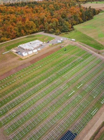 Rural plant for solar installation with adjacent forest in autumn colors, energy revolution,