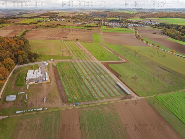 Panoramic view of fields with a solar park and an adjacent small village, Energiewende,