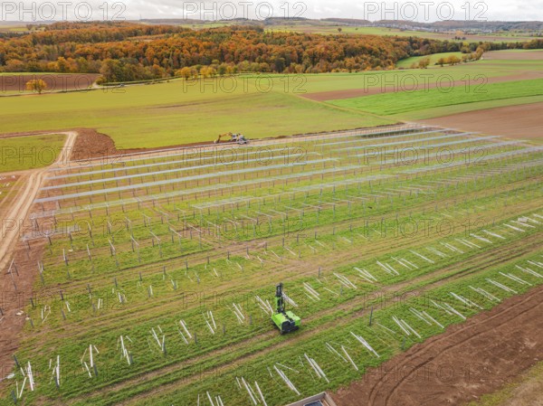Wide fields with solar panels and green landscape in the background, energy revolution,