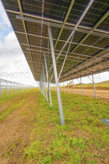 Side view of a large metal structure for solar panels in open countryside, energy revolution,
