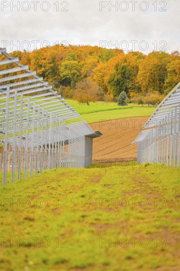 Construction of solar panels between green meadows and fields under autumn skies, energy