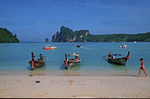 Young woman, longtail boats on the beach of Ko Phi Phi Don, two years in front of the tsunami,