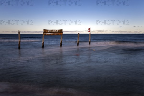 Wooden sign in the sea with inscription Zingst, long exposure, evening light, Zingst,