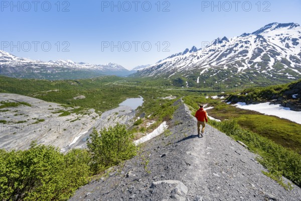 Hikers on glacial moraine, view of the vast Tsina River valley with mountains, Worthington Glacier