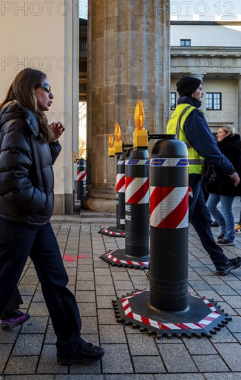 Passers-by at the security barrier made of massive bollards at the Brandenburg Gate passage,