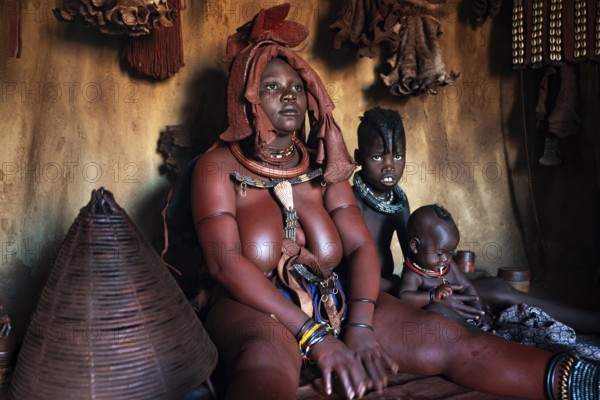 Himba woman sitting with baby, Himba perfume, scented smoke from burning plants, Himba village,