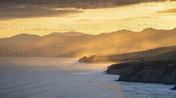 Wairarapa coast at sunset. Sea, mountains, backlight. Castlepoint, Wairarapa Coast, Wellington