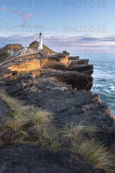 Castlepoint lighthouse on a rock, sea, sunrise. Castlepoint, Wairarapa Coast, Wellington Region,
