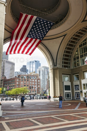 American flag fluttering, distinctive archway, Boston Harbor Hotel, Rowes Wharf, passers-by,