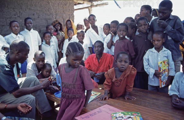 In a World Vision project, friends and neighbors have gathered on the occasion of a godfather's