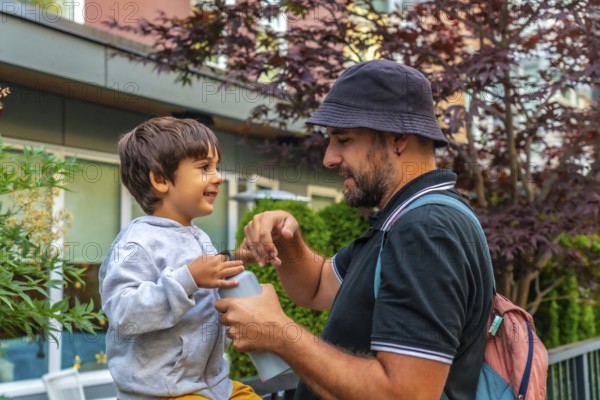 Father and son sharing a joyful bonding moment in vancouver, as dad opens a water bottle for his