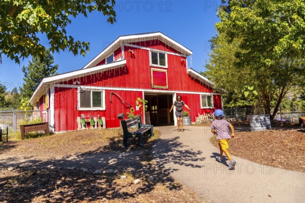 Mother with open arms welcoming her son, joyfully running toward her at the entrance of a large red
