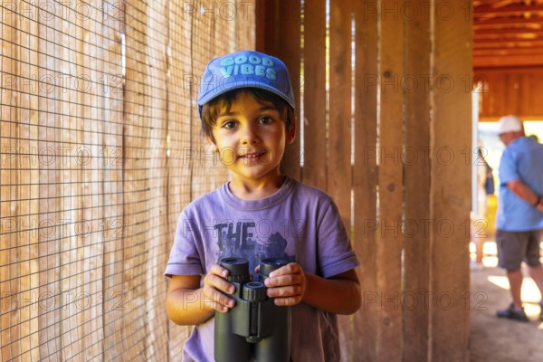 Curious child holding binoculars, exploring the wonders of nature at the british columbia wildlife