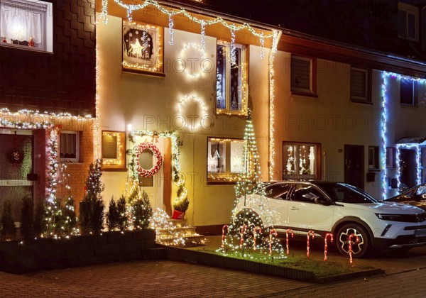 Christmassy kitschy illuminated façade of a row house in Gelsenkirchen-Ückendorf in the evening,