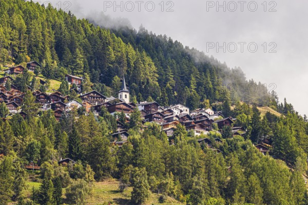Rising fog over the mountain village of Saint-Luc, Val d'Anniviers, Valais Alps, Canton of Valais,