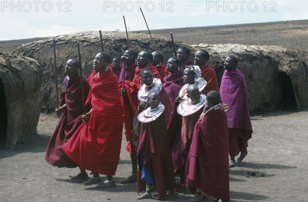 Maasai men and girls in their village in the Ngorongoro Crater dancing for tourists, Tanzania,