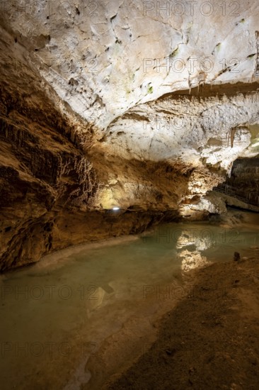 Stalactites and stalagmites, reflection in a small underground lake, rock formations in a