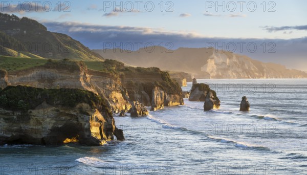 The Three Sisters and Elephant Rock formations, sea, evening, golden hour. Taranaki Region, North