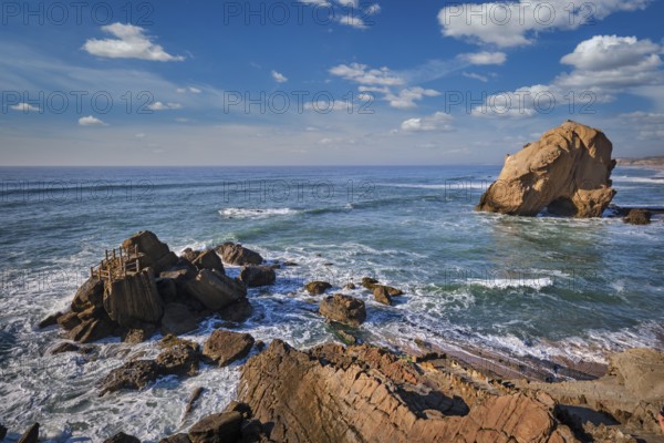 Penedo do Guincho, a large boulder rock arch at Praia da Santa Cruz, Portugal, with ocean waves and