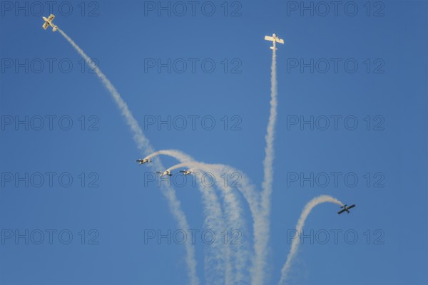 Stunt aerobatic planes performing stunts in blue sky with smoke trail. Concept of teamwork,