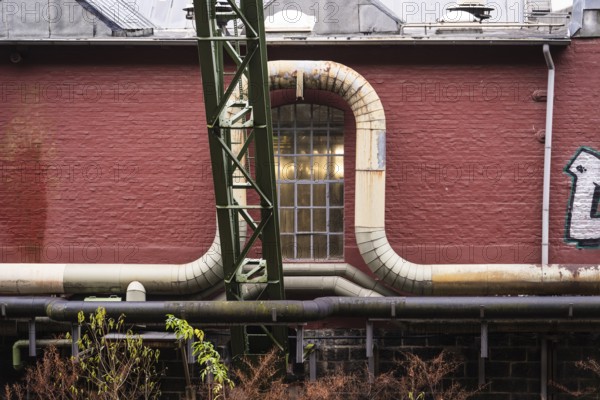 District heating pipeline in front of old industrial buildings on the banks of the Wupper,