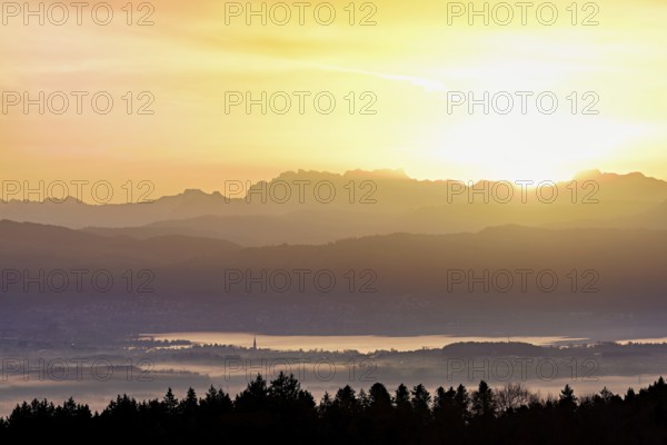 View from Horben of Lake Zug with the city of Cham and Zug covered in fog, behind it the