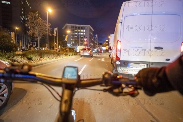 Cycling in the city, in the dark, in the evening, cycling on a bike lane, Huyssenallee, downtown