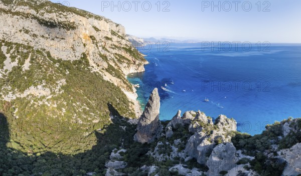Picturesque rocky coast, cliffs with L'Aguglia pinnacle, blue sea and Cala Goloritzé beach, aerial