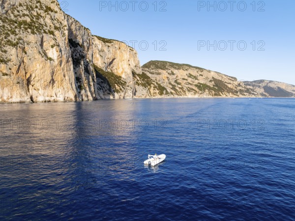 Motorboat off picturesque rocky coast ImmorgenLicht, cliffs, Golfo di Orosei, Baunei, Sardinia,