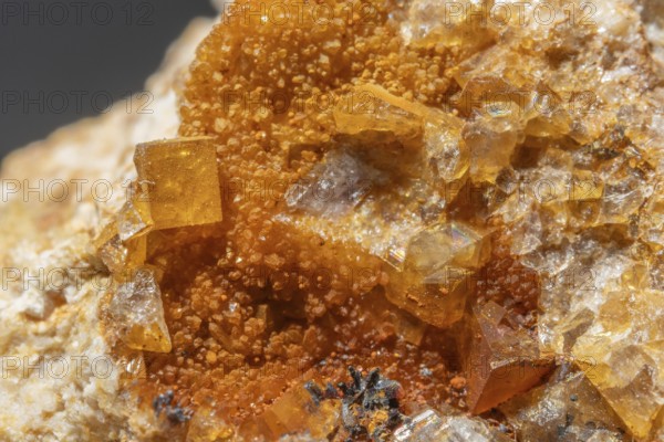 Shiny crystals of blue and orange color can be seen in this mineral formation. They are sparkling