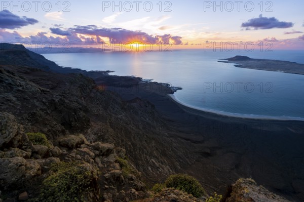 View from steep cliffs to sea and coast with sun stars, Mirador del Porrito viewpoint at sunset,