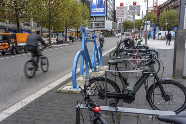 Bicycle parking spaces, with so-called leaning bars and a large blue bicycle silhouette, to make