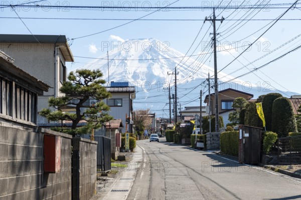 Street scene in a residential area, residential buildings and power lines, view of Mt. Fuji,