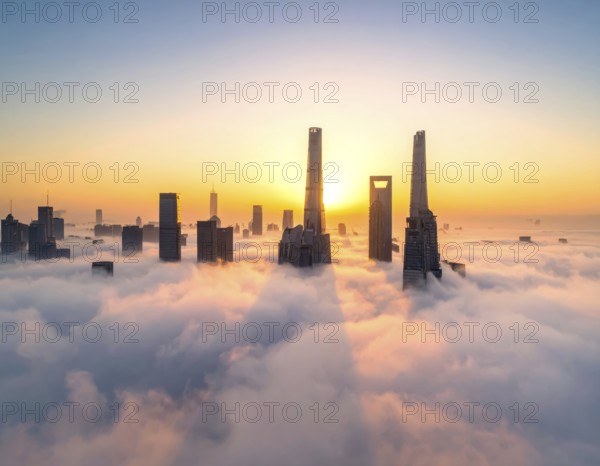 City scape emerging from a dense enveloping fog in sunrise and skyscrapers piercing the haze, big