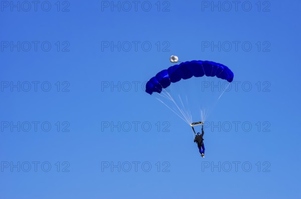 Skydivers during an aerial acrobatic performance as part of an air show at the Fliegerbergfest of