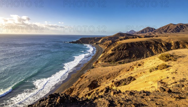 Desert landscape converges with ocean along a rugged coastal area, shore break at cliffs, blue