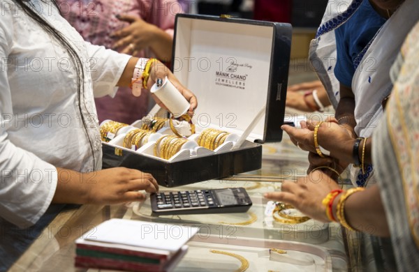 Customers purchase Gold jewelry at a store on the occasion of the festival of Dhanteras, in