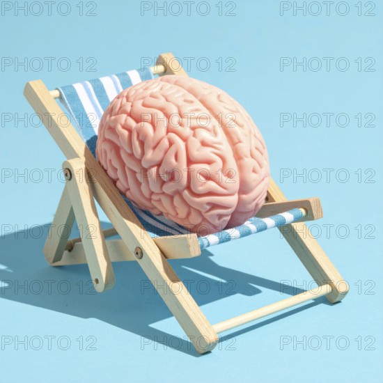 Brain relaxes on a sunbed under the summer sun, placed on a flat surface, symbol for mental health,
